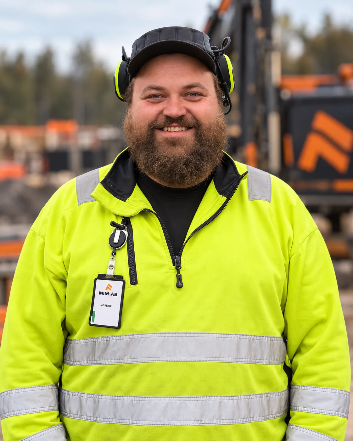 Jeppe i varselkläder, keps och hörselkåpor på en byggarbetsplats